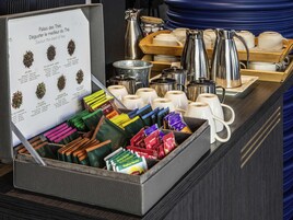 Una estación de té con varias bolsitas y un cartel que describe diferentes tipos de té.
