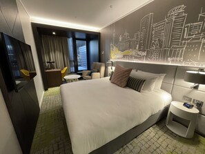 A modern hotel room with a large bed, a cityscape mural, a desk, and a chair. - Mercure Auckland Queen Street (Auckland)