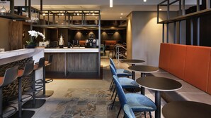 A modern bar area with seating, a counter, and pendant lighting. - Mercure Auckland Queen Street (Auckland)