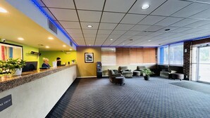 A reception area with a counter, seating, and a large window. - Rodeway Inn Silver Springs (Silver Springs)