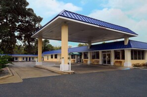 A motel with a covered parking area, a single-story building, and a blue roof. - Rodeway Inn Silver Springs (Silver Springs)