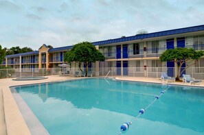 Un hotel con piscina, varios balcones y una decoración en blanco y azul.