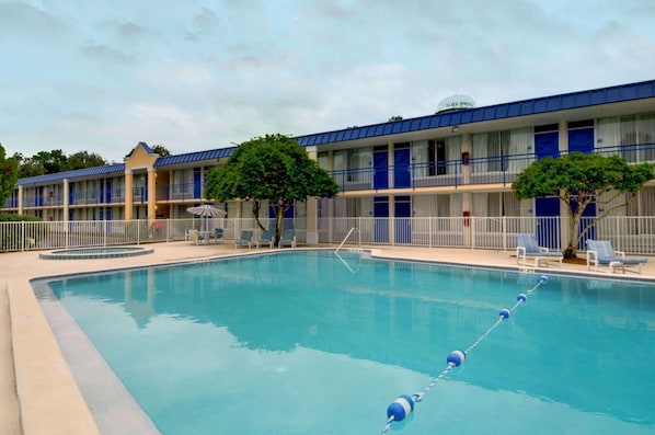 A hotel with a swimming pool, multiple balconies, and a clear sky. - Rodeway Inn Silver Springs (Silver Springs)