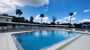 A rectangular swimming pool with a white deck, surrounded by a white fence. - Rodeway Inn Silver Springs (Silver Springs)