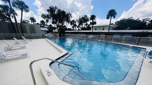 A swimming pool with lounge chairs and a lifeguard stand. - Rodeway Inn Silver Springs (Silver Springs)