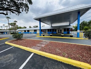 A gas station with a blue and white building, a covered parking area, and a parking lot with yellow curbs. - Rodeway Inn Silver Springs (Silver Springs)
