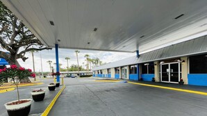 A gas station with a covered parking area, fuel pumps, and a building with large windows and a blue and white color scheme. - Rodeway Inn Silver Springs (Silver Springs)