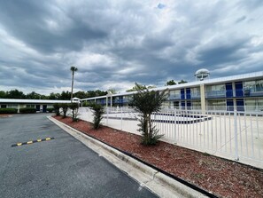 Um hotel com fachada branca, vários andares e um reservatório de água no telhado.