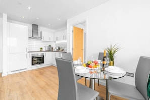 A modern kitchen with white cabinets, a built-in oven, and a stainless steel range hood. - Birmingham City Centre - 2 Bed - Secure Parking
 (West Midlands)