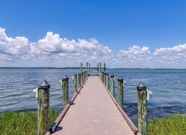 Un muelle de madera que se adentra en aguas tranquilas bajo un cielo despejado.
