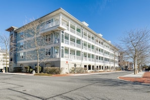 A multi-story hotel with a white facade, large windows, and a flat roof. - Sunset Island 6 Sunset Island Drive, Unit 4F (Ocean City)