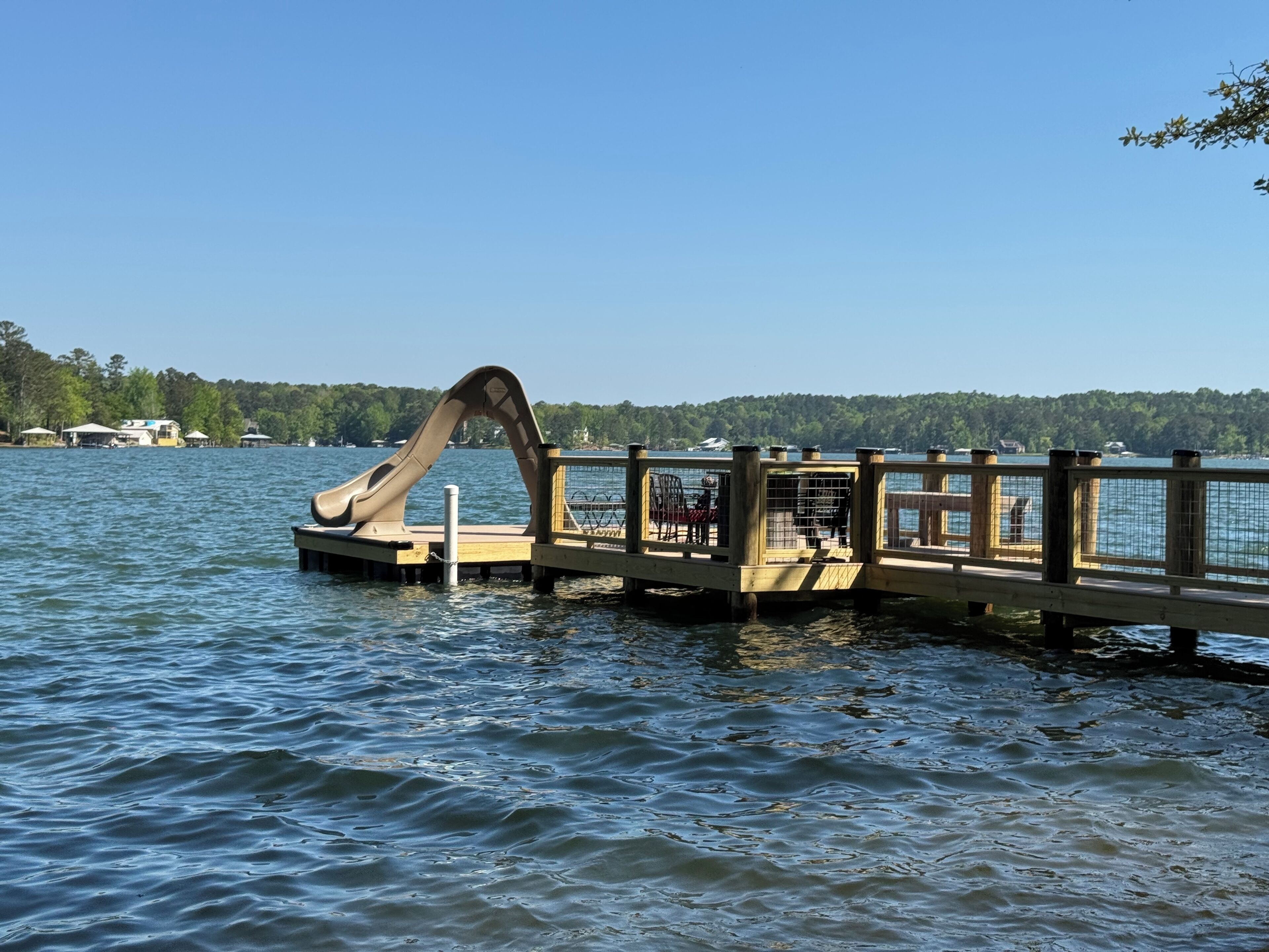 Eine Holzstege, der sich in einen See erstreckt, mit einer Wasserrutsche.