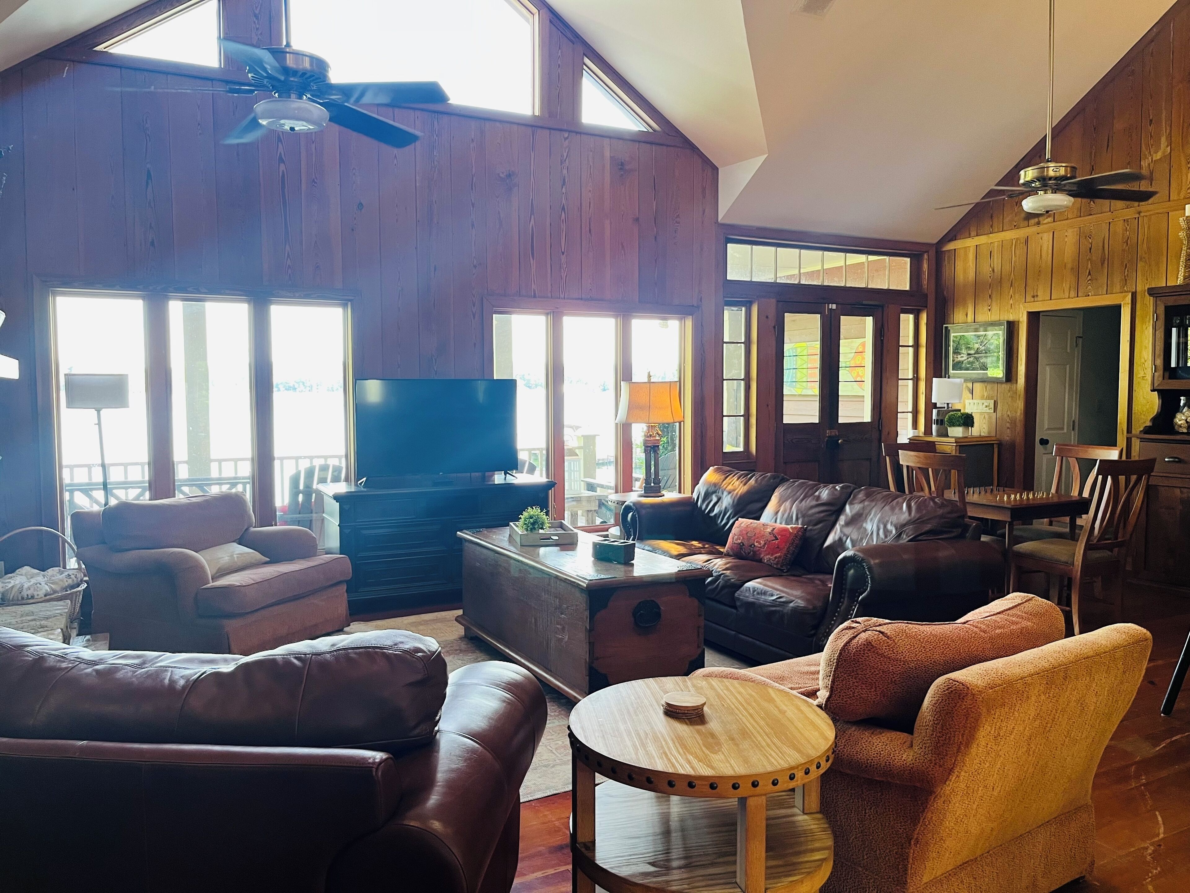 A spacious living room with a fireplace, leather sofas, a wooden coffee table, and a television.