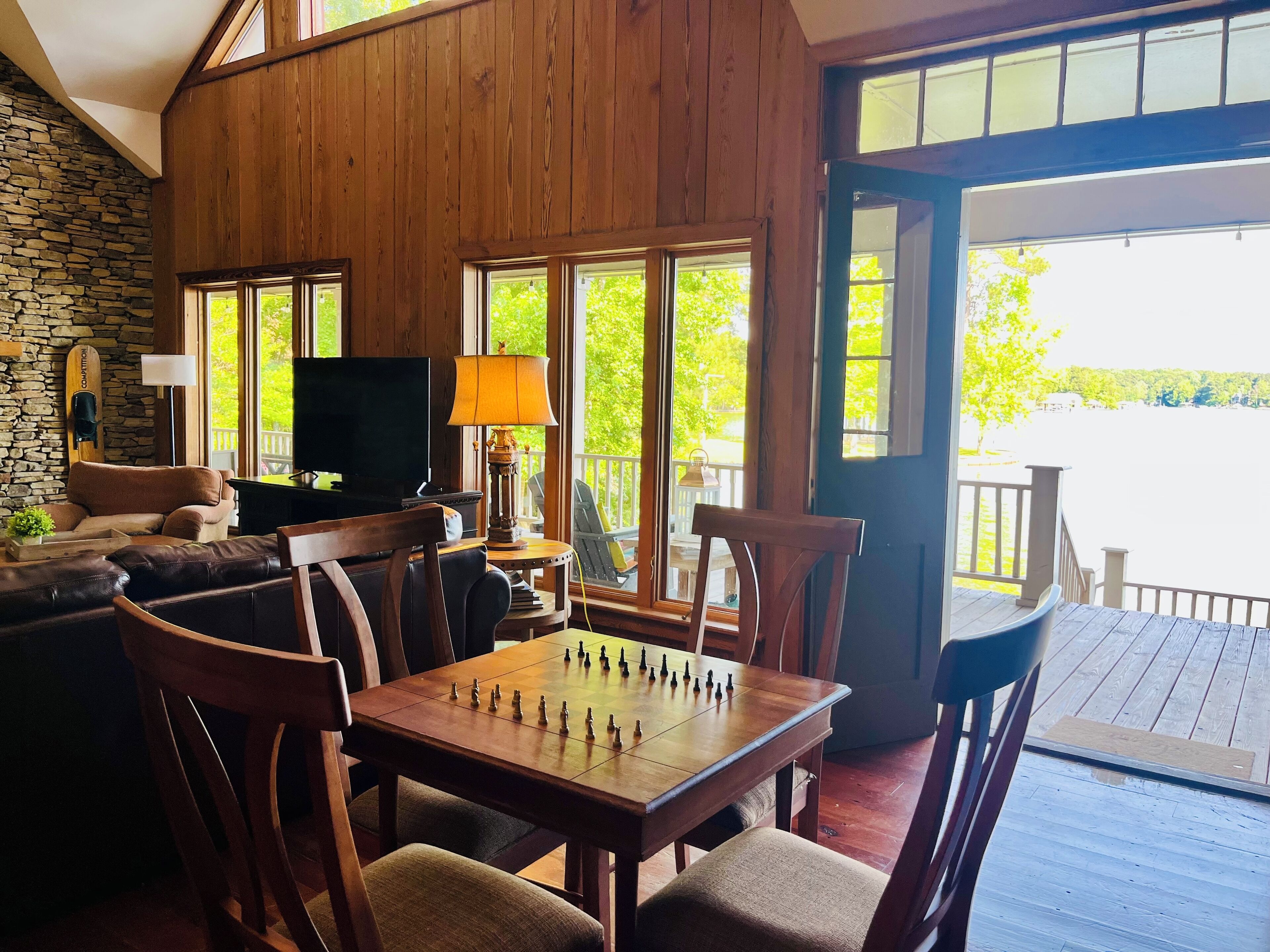 Un salon confortable avec une cheminée, un téléviseur et une table d’échecs.