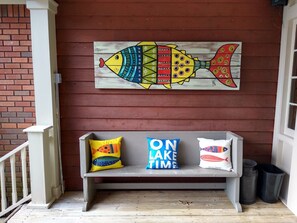 A bench with colorful pillows and a painted fish mural on a wooden wall. - Dock. Waterslide. Beach. Firepit, Gazebo, 500ft water frontage. Views. Sleep 18. (Equality)