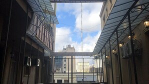 A high-rise building with a glass facade, a pedestrian bridge, and a view of the cityscape. - Bagu Buenos Aires (Buenos Aires)