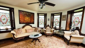 Una habitación con sofá, sillones, una mesita de centro y un ventilador de techo.
