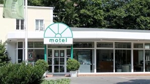 A modern motel with a large glass facade and a prominent green logo. - Motel Frankfurt by Advena (Frankfurt)