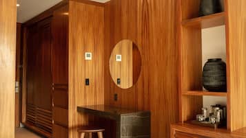Un interior de madera con un armario grande, un espejo redondo y una repisa con objetos decorativos.