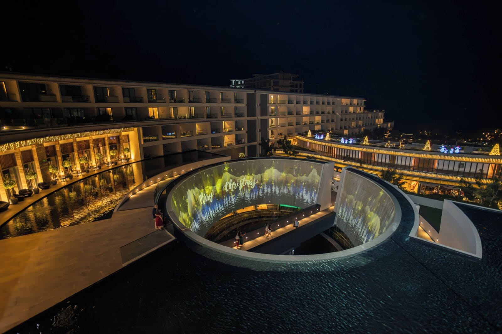 Un hotel moderno con un atrio circular y una piscina.