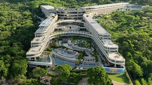 Un resort con piscina central, varias piscinas y una zona de playa.