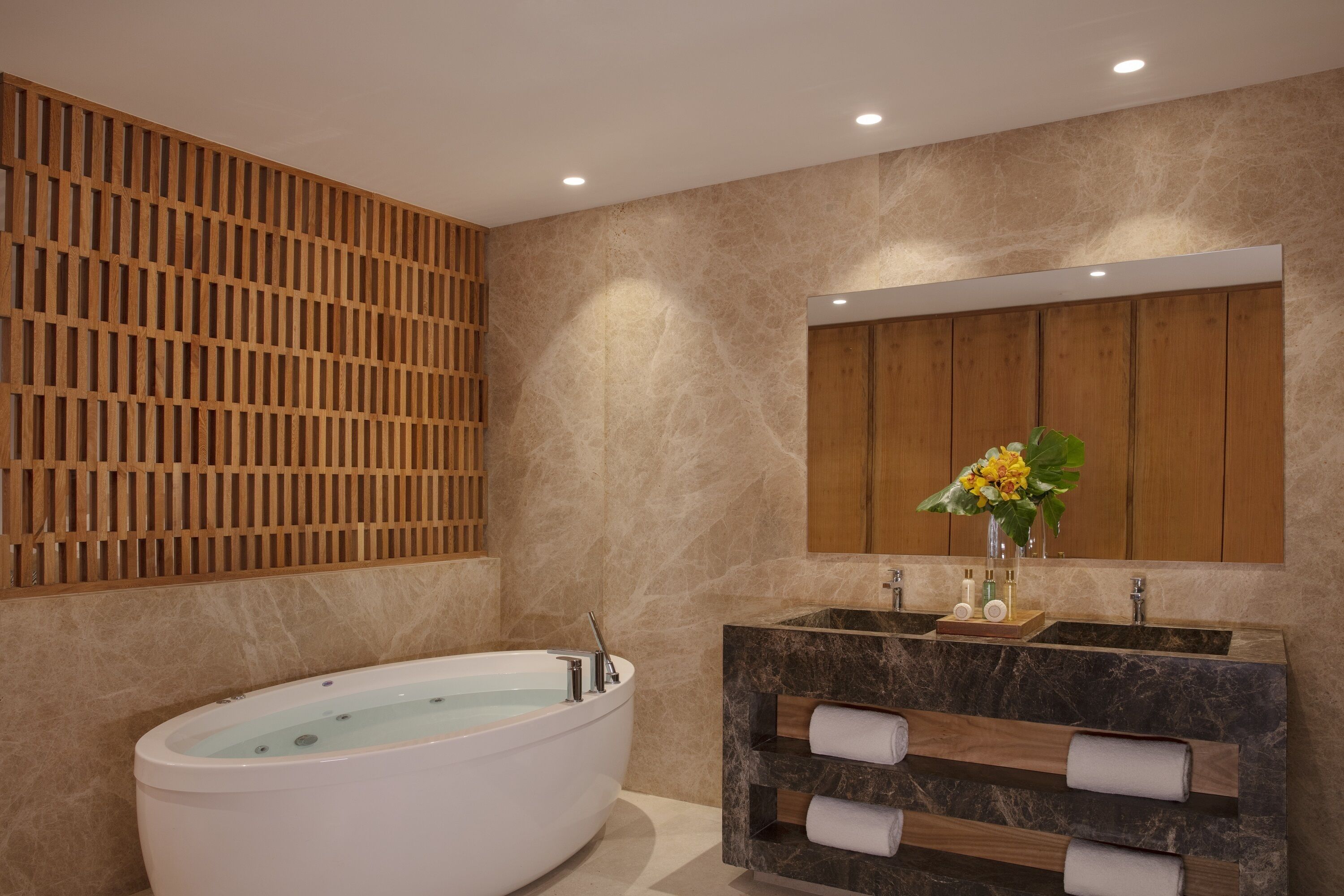 A modern bathroom with a freestanding bathtub, a wooden vanity with marble countertops, and a large mirror above the sink.