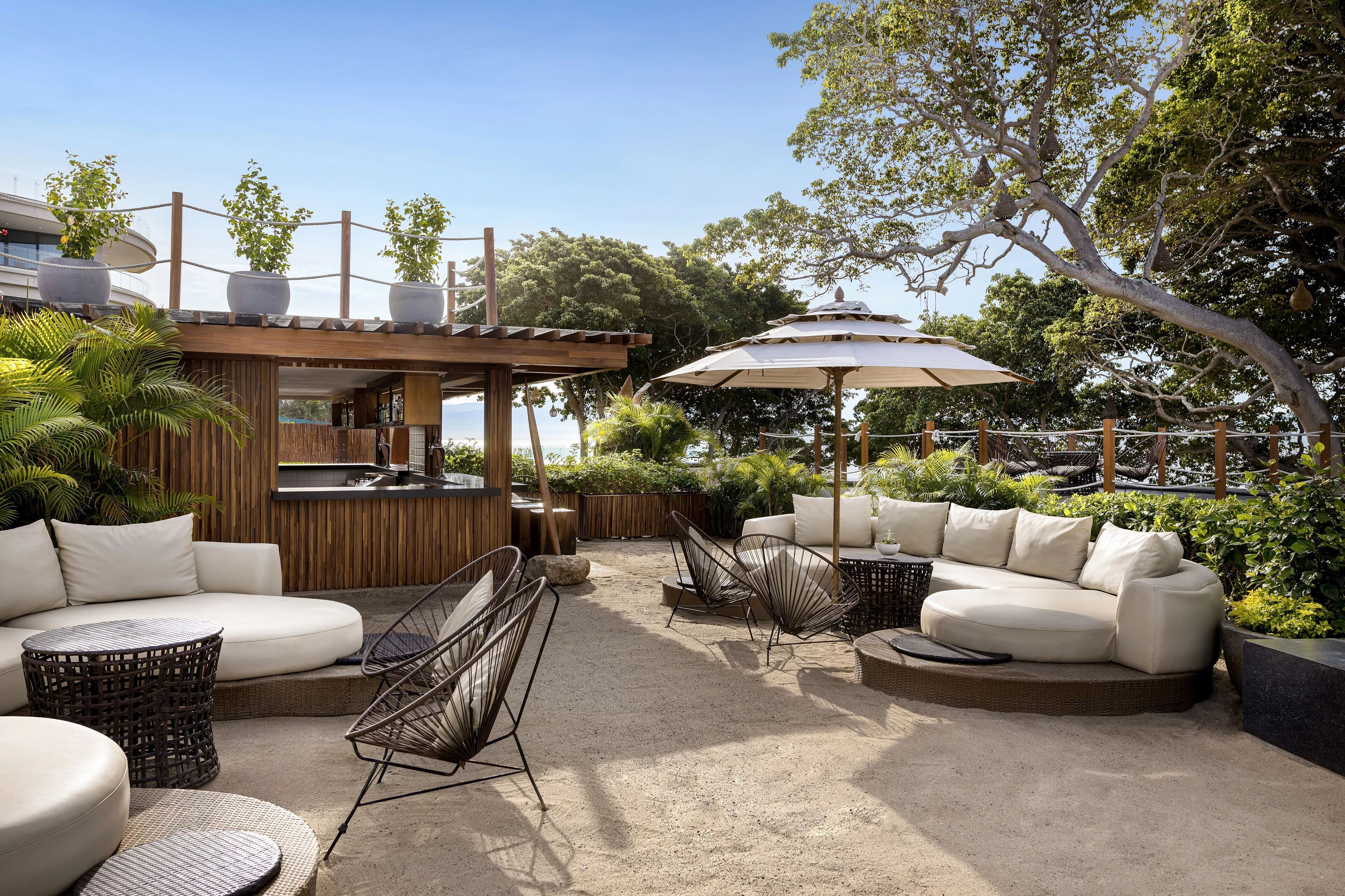 An outdoor patio with a sofa, chairs, and a small bar area.