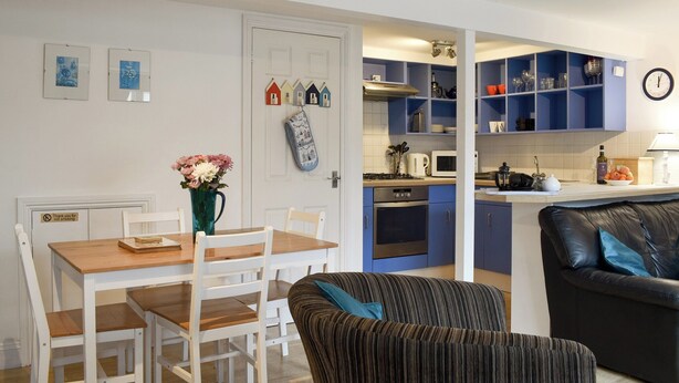 Un espace de vie compact comprenant un coin repas, une cuisine et un coin salon.