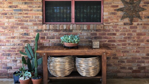 Un muro di mattoni con una finestra, un cactus e una decorazione a stella.