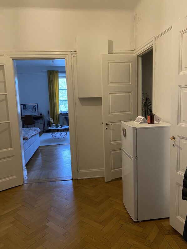 A compact living space with a kitchenette, a bed, and a dining area.