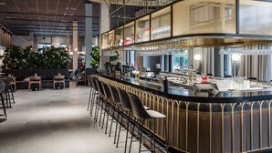 A modern bar area with a curved counter, bar stools, and a seating area with tables and chairs. - Clarion Hotel Sundsvall (Sundsvall)