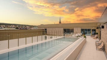 Una piscina al aire libre, sillones reclinables de piscina