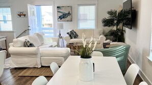 Un salon moderne avec un canapé blanc, une table à manger et un ventilateur de plafond.