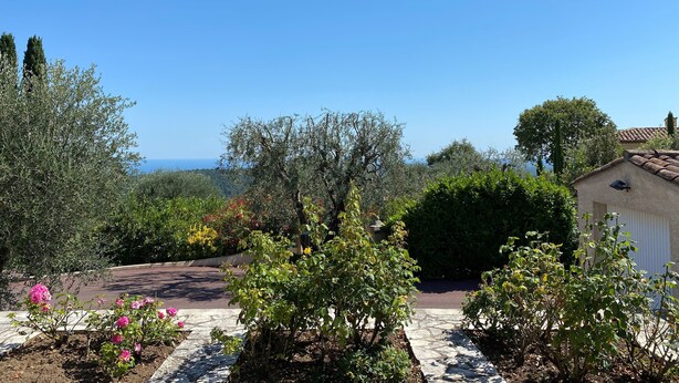 A garden with a stone pathway, various shrubs, and a view of the sea. - L'Aminèxe - simple quiet under the stars in the fresh air (Tourrettes-sur-Loup)