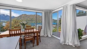 A dining area with a view of mountains and a lake.