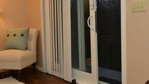 A room with a sliding glass door leading to a balcony, a sofa with cushions, a white rug, and a lamp. - 2 Bedroom Oasis! Mother in-Law Apt Forest Lake, MN (Forest Lake)