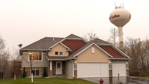 A two-story house with a garage, a satellite dish, and a water tower in the background. - 2 Bedroom Oasis! Mother in-Law Apt Forest Lake, MN (Forest Lake)