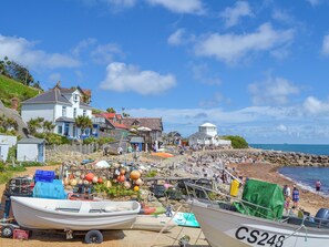 A coastal town with a beach, boats, and buildings.