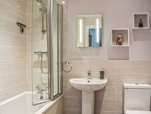A modern bathroom with a glass-enclosed shower, a pedestal sink, and a toilet.