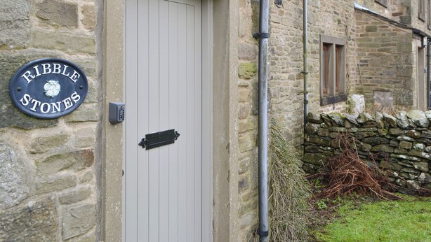 Un bâtiment en pierre avec une porte portant l’inscription « Ribble Stones ».