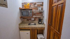 A compact kitchenette with a microwave, sink, coffee maker, and a small refrigerator. - Campo Verde (La Fortuna)