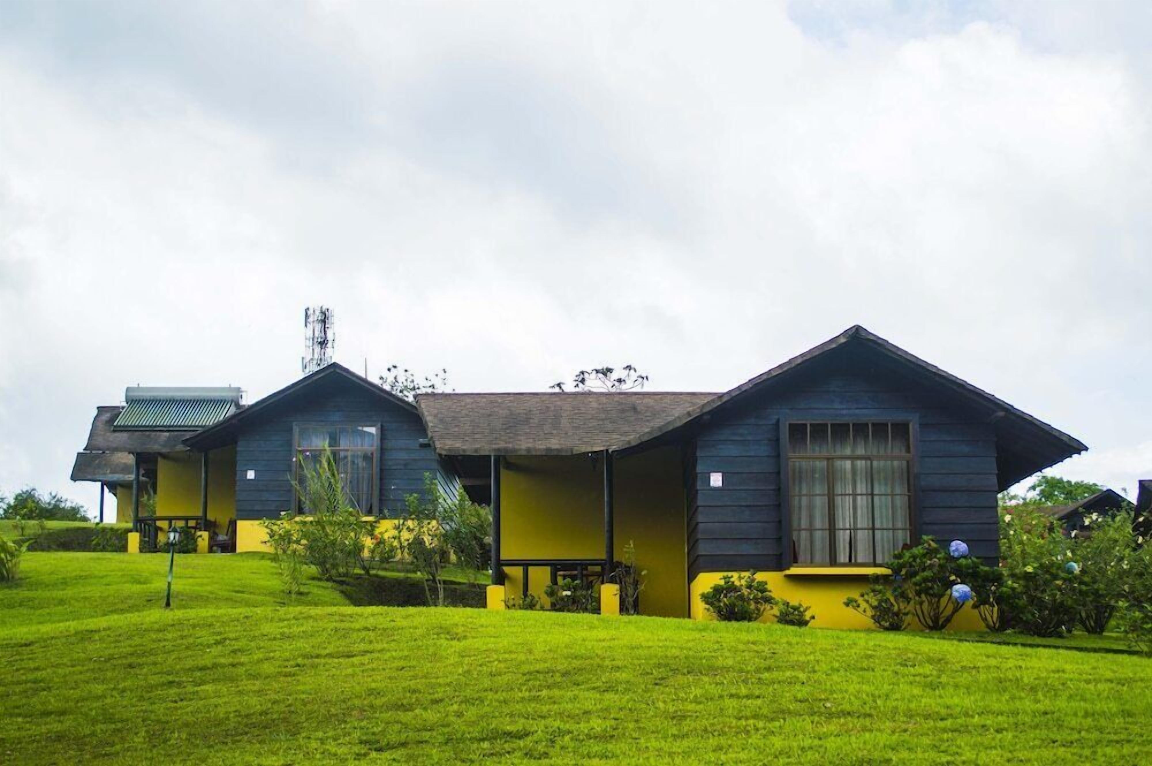 A row of two-story houses with a flat roof, each with a porch and a window.