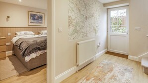 Une chambre avec un lit, un radiateur, une carte accrochée au mur et une fenêtre.