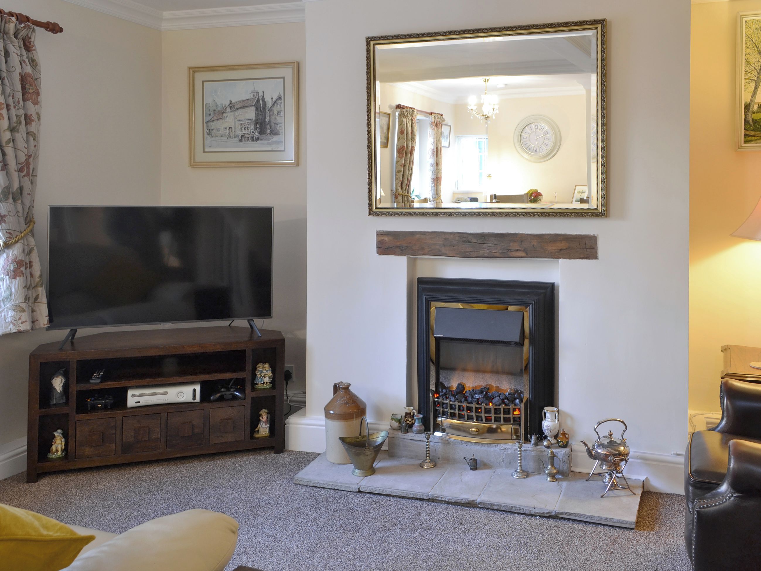 A living room with a television, fireplace, and decorative items.