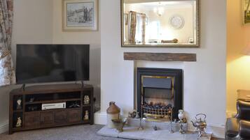 A living room with a television, fireplace, and decorative items.