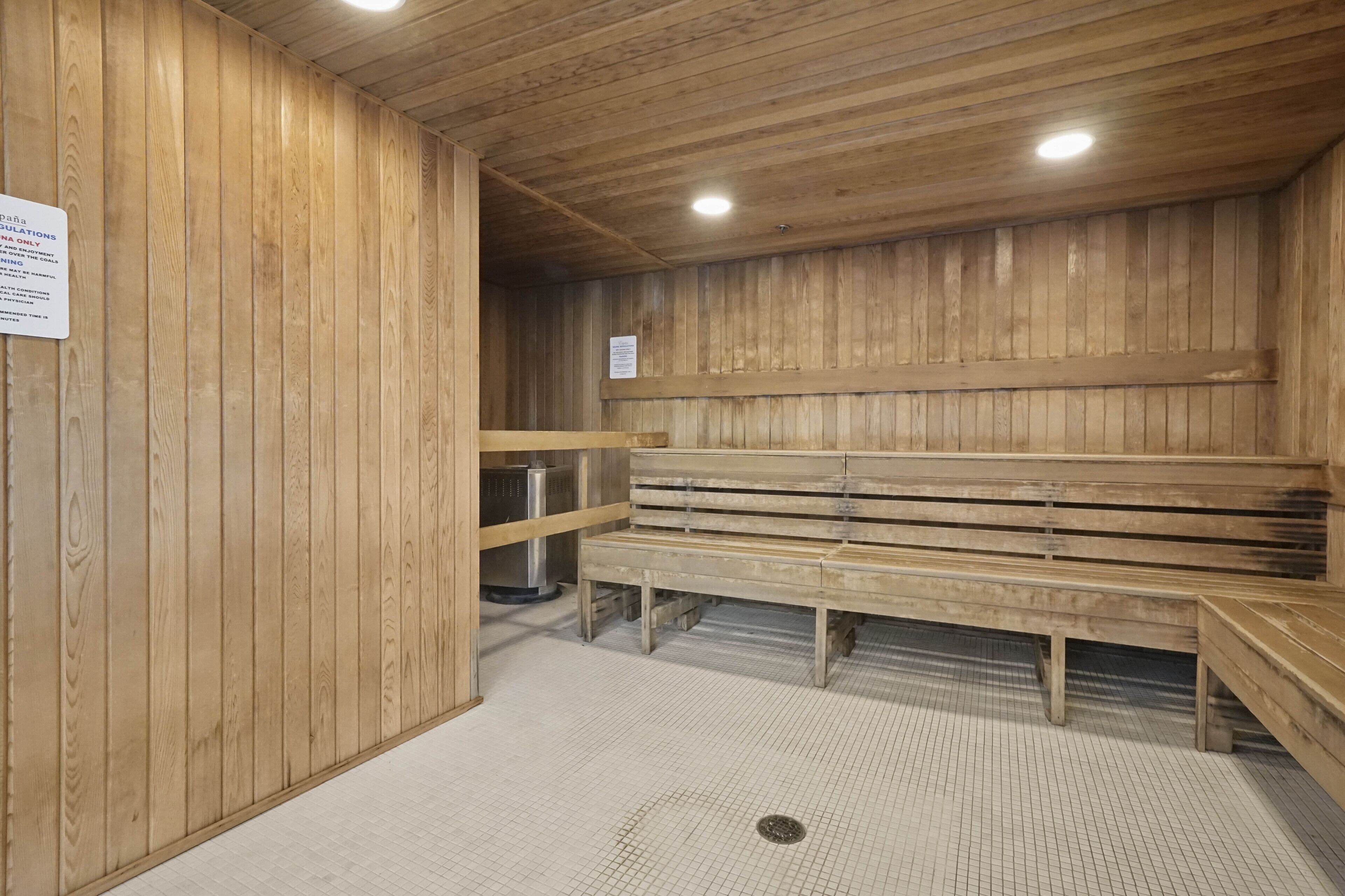 Een sauna met houten banken en een betegelde vloer.