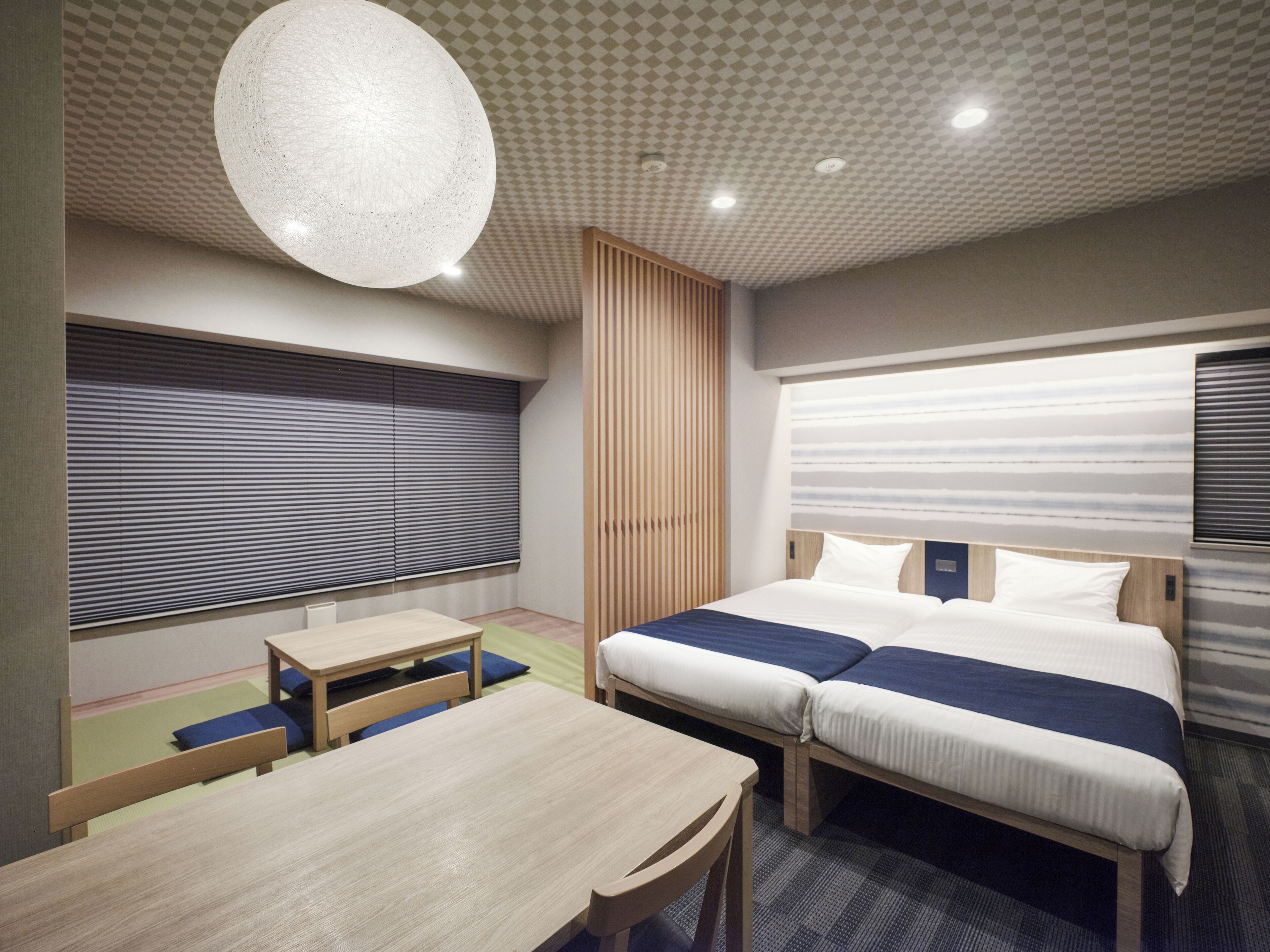 A modern hotel room with a large bed, a desk, and a seating area.