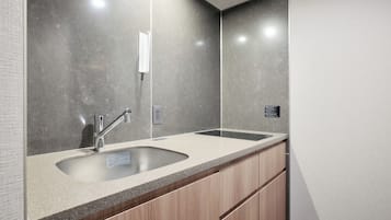 A modern bathroom with a large sink, a mirror, and a wooden cabinet.