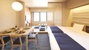 A hotel room with a large bed, a dining table with chairs, and a small seating area.