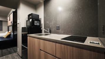 A modern kitchen with a built-in microwave, a sink, and wooden cabinets.